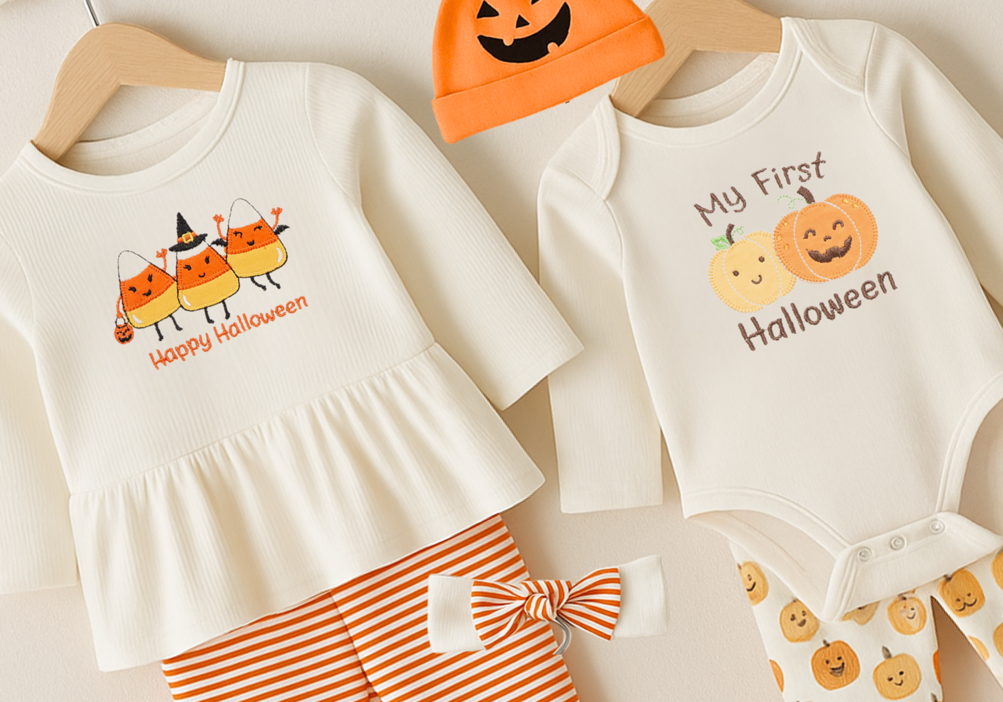 Halloween-themed children's clothing set with a dress, onesie, and hat on a neutral background.